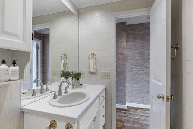 bathroom featuring ornamental molding, vanity, and tile walls