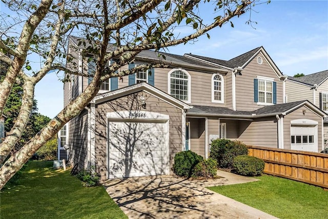 view of front facade with a garage, concrete driveway, fence, and a front lawn