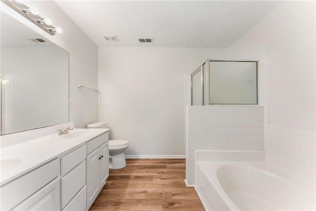 full bath featuring a bath, wood finished floors, a sink, and visible vents