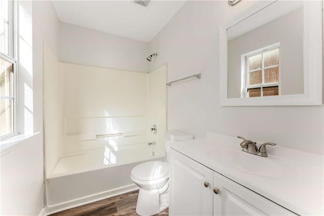 full bathroom with visible vents, toilet, washtub / shower combination, vanity, and wood finished floors