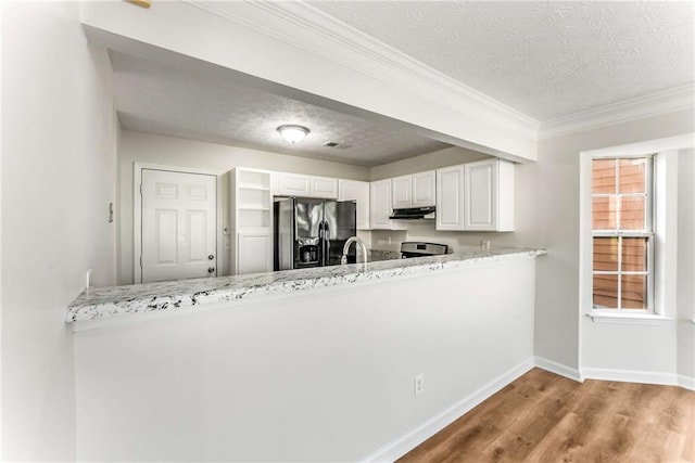 kitchen with black fridge with ice dispenser, white cabinets, a peninsula, wood finished floors, and under cabinet range hood