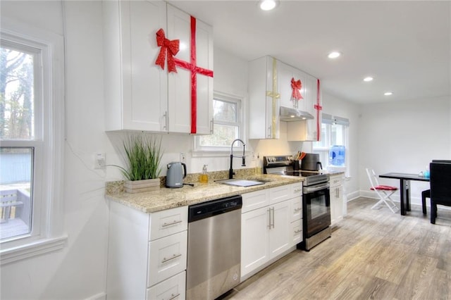 kitchen featuring white cabinets, stainless steel appliances, plenty of natural light, and sink