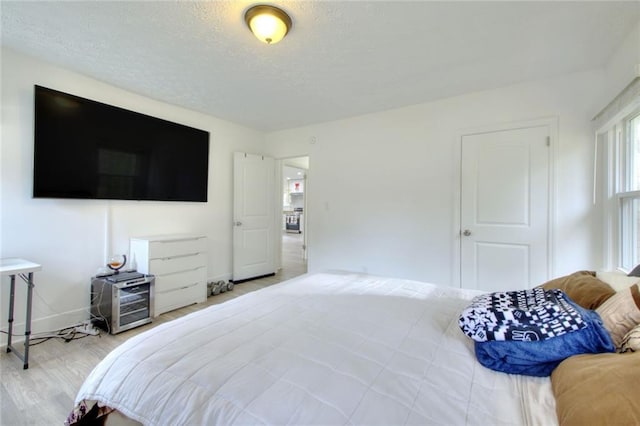 bedroom featuring light hardwood / wood-style flooring and a textured ceiling