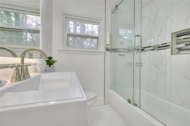 full bathroom featuring bath / shower combo with glass door, toilet, a healthy amount of sunlight, and sink