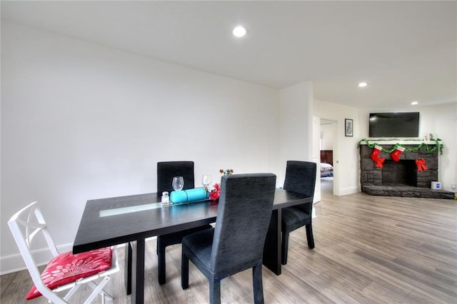 dining area with a fireplace and wood-type flooring