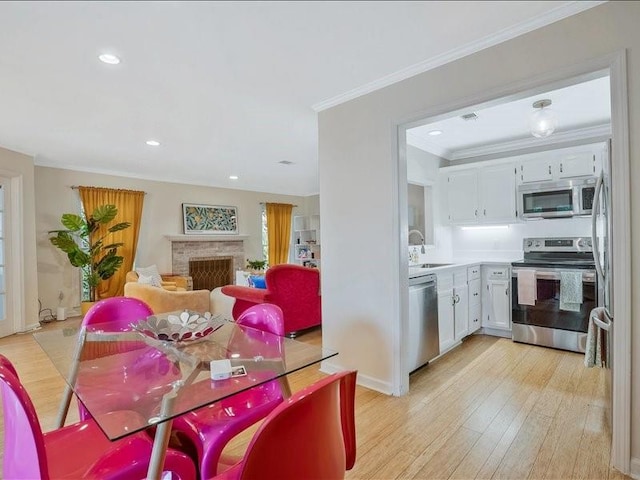 212 Abingdon Way, Atlanta, GA 30328 - dining space with light wood-style floors, recessed lighting, crown molding, a fireplace, and baseboards