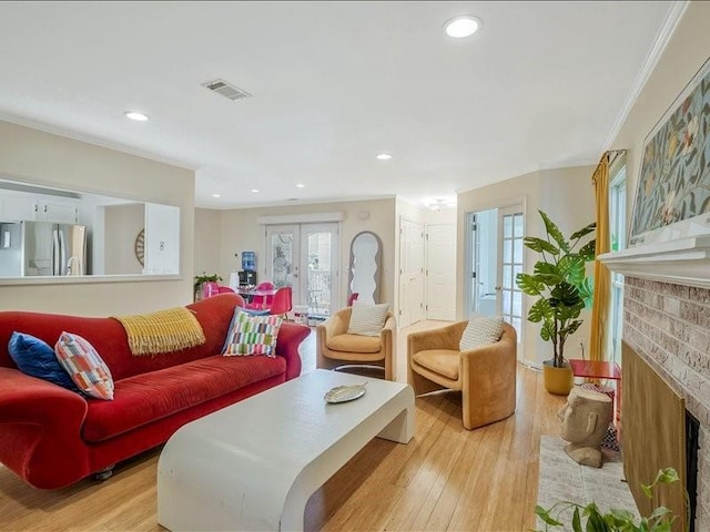 212 Abingdon Way, Atlanta, GA 30328 - living room featuring a brick fireplace, light wood finished floors, crown molding, recessed lighting, and french doors