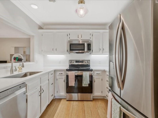 212 Abingdon Way, Atlanta, GA 30328 - kitchen featuring appliances with stainless steel finishes, a sink, white cabinetry, light countertops, and light wood-type flooring