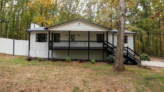 view of front of home with stairs, a front lawn, a chimney, and fence