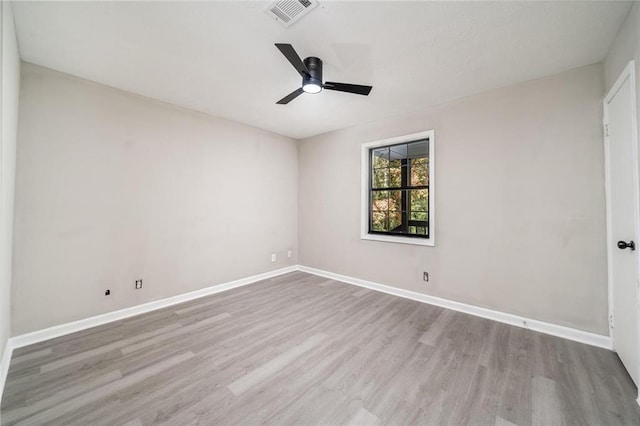 empty room featuring a ceiling fan, baseboards, visible vents, and light wood finished floors