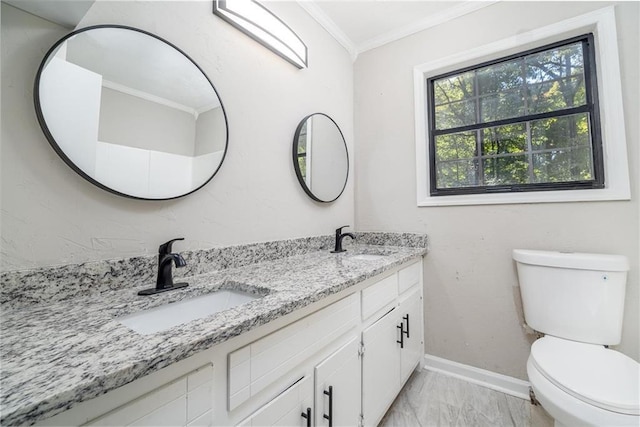 bathroom with double vanity, marble finish floor, crown molding, and a sink