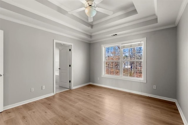 spare room with ceiling fan, crown molding, light wood-type flooring, and a tray ceiling