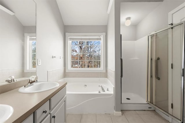 bathroom with tile patterned flooring, vanity, and plus walk in shower