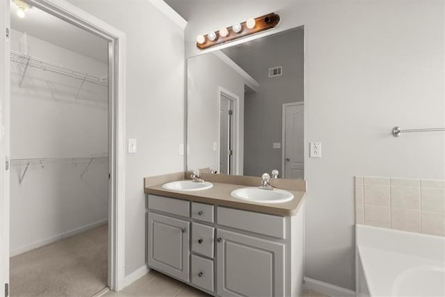 bathroom featuring vanity, tile patterned floors, and a bathing tub