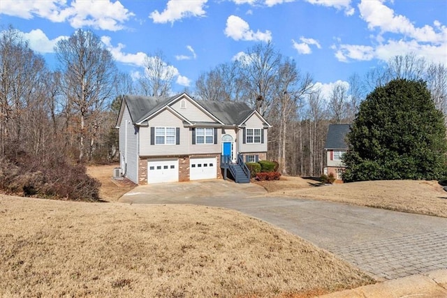 bi-level home with a garage and a front yard