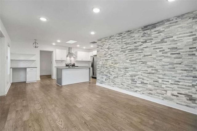 unfurnished living room featuring wood-type flooring and sink