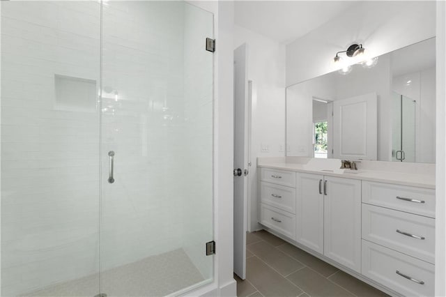 bathroom with walk in shower, vanity, and tile patterned flooring