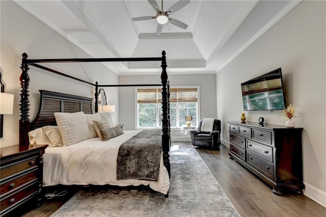 bedroom with ceiling fan, crown molding, wood-type flooring, and a raised ceiling