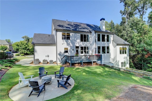 back of house with cooling unit, a deck, a patio area, and a lawn