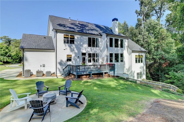 rear view of property with central air condition unit, an outdoor fire pit, a deck, a lawn, and a patio