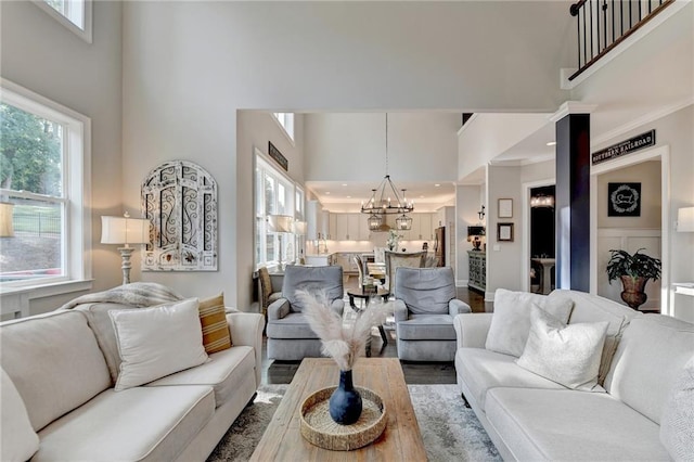 living room with a towering ceiling, plenty of natural light, and hardwood / wood-style floors