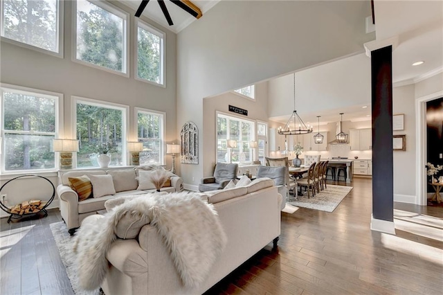 living room featuring crown molding, high vaulted ceiling, ceiling fan with notable chandelier, and dark hardwood / wood-style flooring