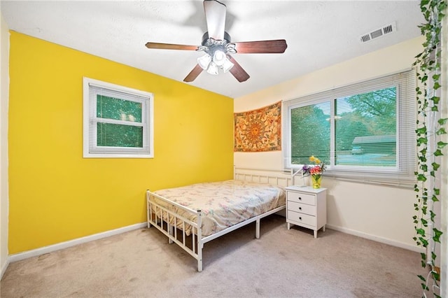 bedroom featuring ceiling fan and light carpet