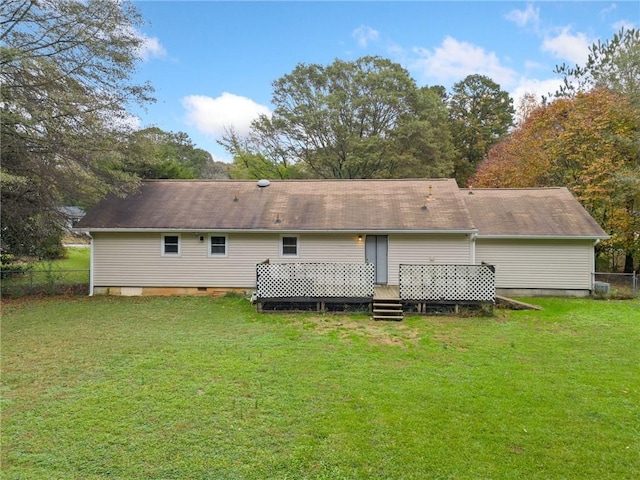 rear view of house with a lawn and a wooden deck