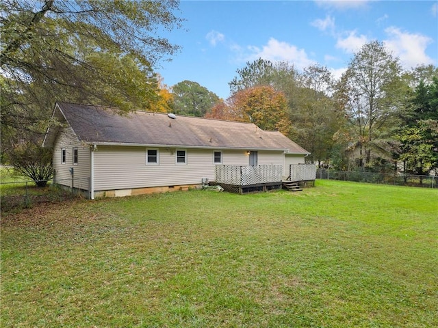 back of property with a lawn and a wooden deck