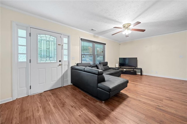 living room with crown molding, ceiling fan, a textured ceiling, and hardwood / wood-style flooring