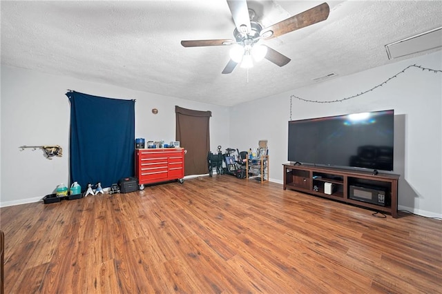 miscellaneous room featuring ceiling fan, wood-type flooring, and a textured ceiling