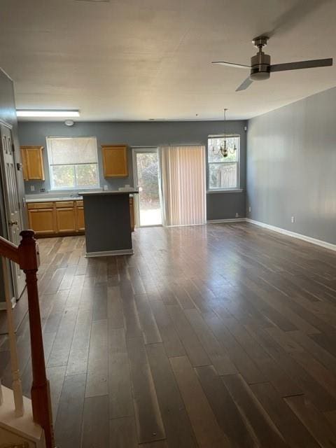 interior space featuring hanging light fixtures, dark hardwood / wood-style floors, a kitchen island, and ceiling fan