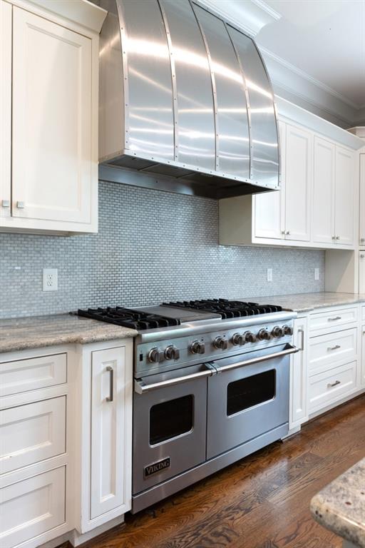 22 Mount Paran Rd, Atlanta, GA 30327 - kitchen with range with two ovens, ventilation hood, crown molding, white cabinetry, and backsplash