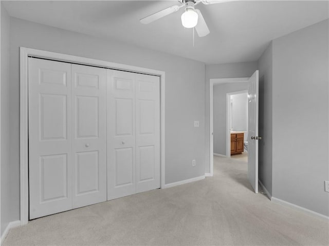 unfurnished bedroom with ceiling fan, a closet, and light carpet