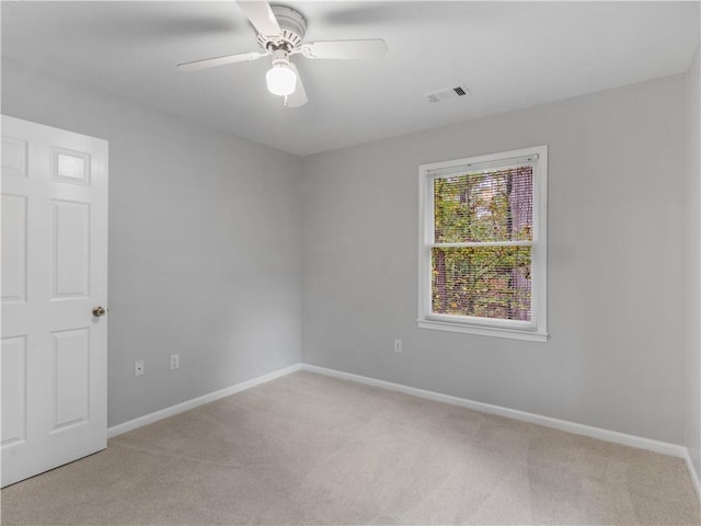 carpeted spare room featuring ceiling fan