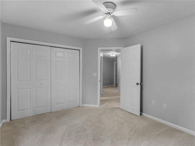 unfurnished bedroom with ceiling fan, light colored carpet, and a closet