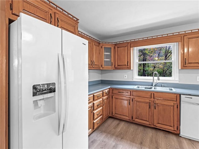 kitchen featuring sink, white appliances, and light wood-type flooring