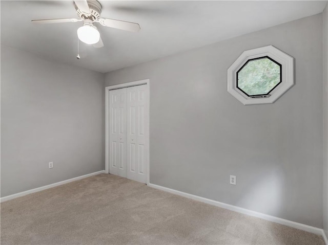 carpeted spare room with ceiling fan