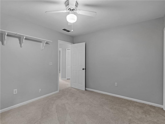 spare room with ceiling fan and light colored carpet