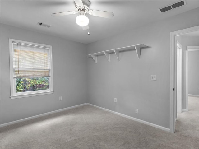 empty room featuring ceiling fan and light carpet