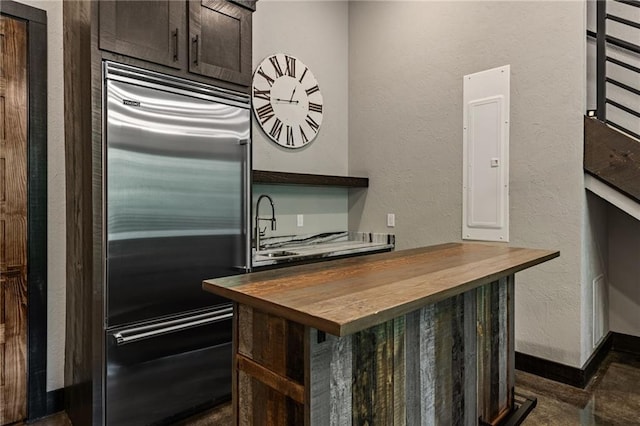 453 Settlers Ridge Rd, Ellijay, GA 30540 - kitchen featuring butcher block counters, built in refrigerator, dark brown cabinets, and a textured wall