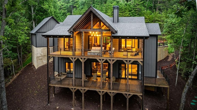 453 Settlers Ridge Rd, Ellijay, GA 30540 - back of house with a balcony, a shingled roof, a chimney, board and batten siding, and a view of trees
