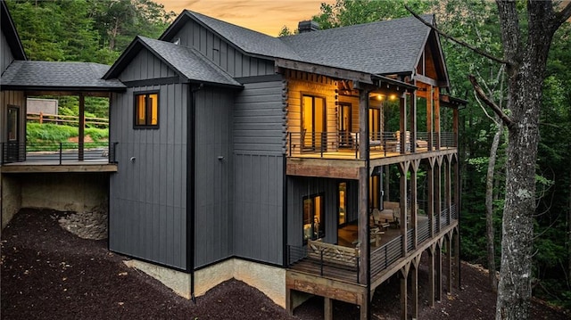 453 Settlers Ridge Rd, Ellijay, GA 30540 - back of property at dusk with a balcony, a shingled roof, and a chimney
