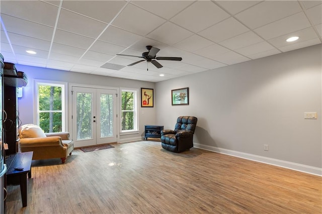 living area featuring ceiling fan, a paneled ceiling, french doors, and plenty of natural light