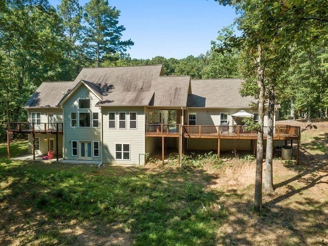 rear view of house with a deck and a lawn