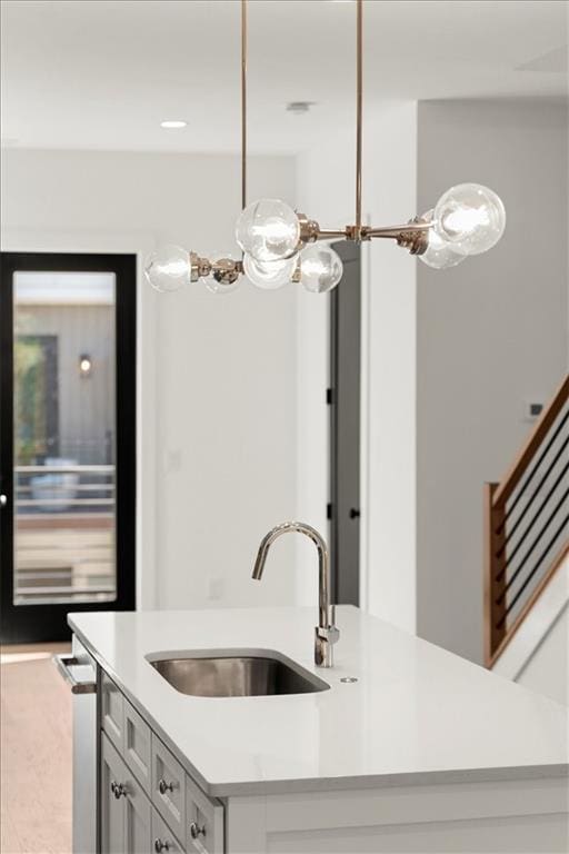 kitchen featuring a kitchen island with sink, hanging light fixtures, and sink