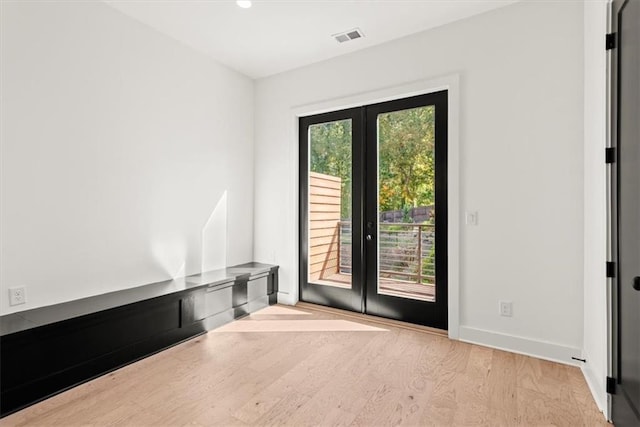 doorway to outside featuring a wealth of natural light, french doors, and light wood-type flooring