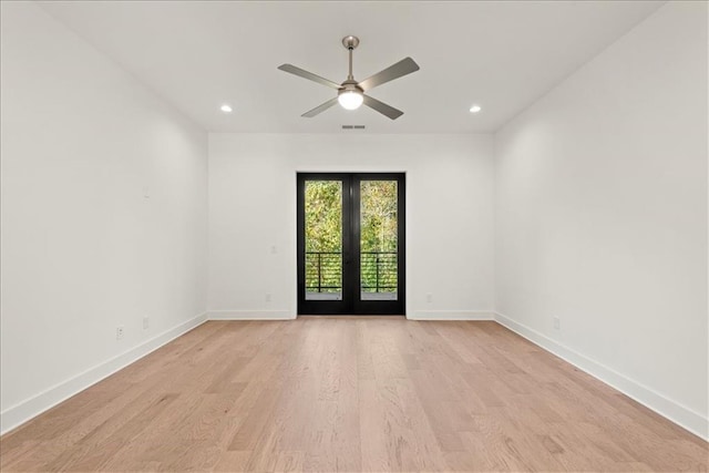 empty room featuring ceiling fan, french doors, and light wood-type flooring