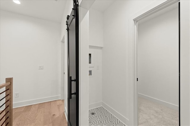 hall featuring light hardwood / wood-style flooring and a barn door