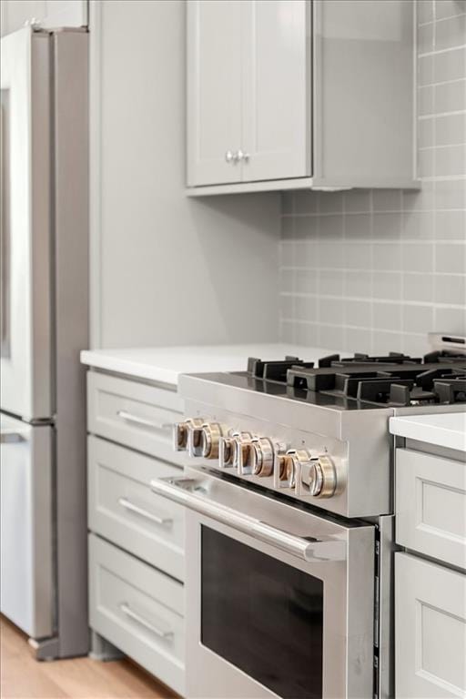 kitchen with appliances with stainless steel finishes, white cabinetry, and tasteful backsplash